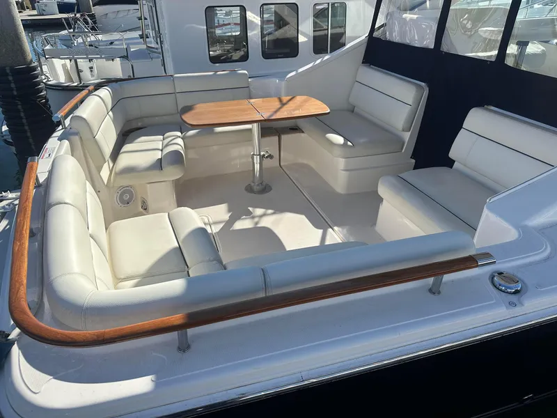 Slide: The Image of 2016 Tiara Yachts 3100 Coronet with spacious seating and wooden table on deck. - 5