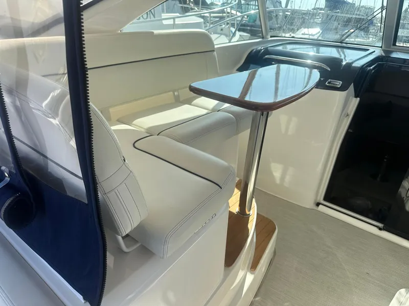 Slide: The Image of 2016 Tiara Yachts 3100 Coronet interior with seating and wooden table. - 7