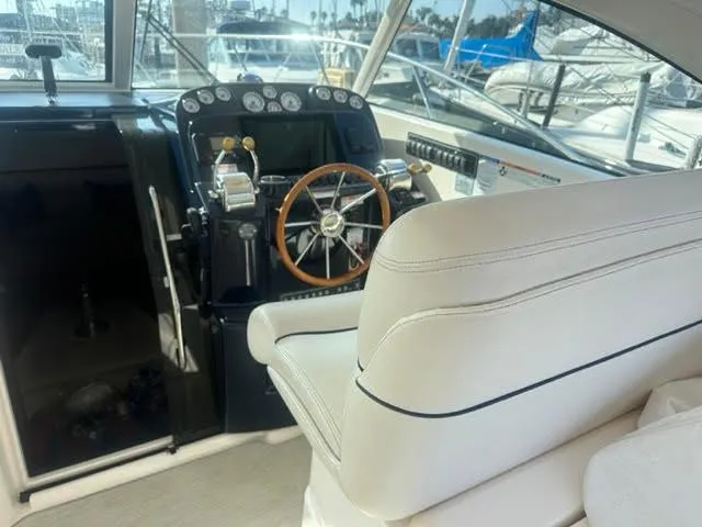 Slide: The Image of 2016 Tiara Yachts 3100 Coronet helm with white seating and wooden steering wheel. - 9