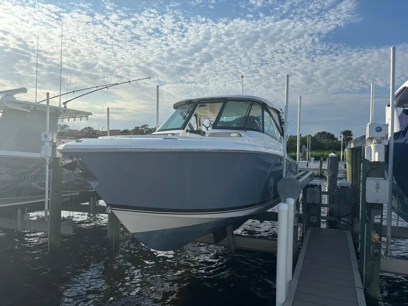 Slide: The Image of 2021 Pursuit DC 295 Dual Console boat docked under a cloudy sky. - 4