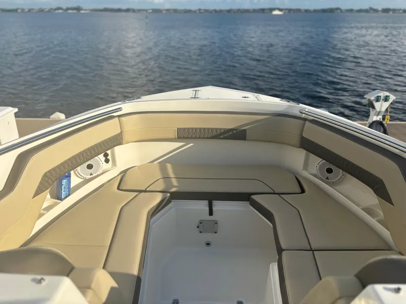 Slide: The Image of 2021 Pursuit DC 295 Dual Console boat interior with beige seating, overlooking calm waters. - 5