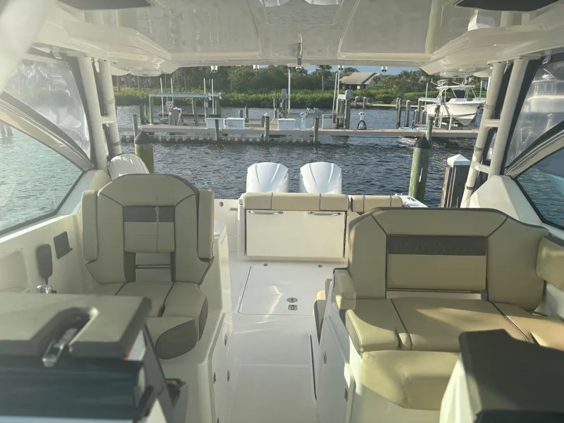 Slide: The Image of 2021 Pursuit DC 295 Dual Console boat interior with seating, docked at marina. - 6