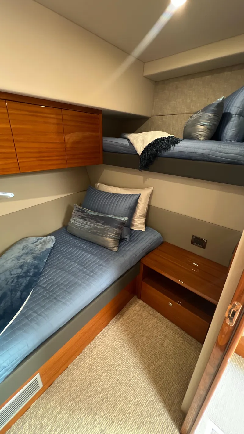 Slide: The Image of 2021 Maritimo X60 yacht cabin with twin beds and wooden storage. - 43