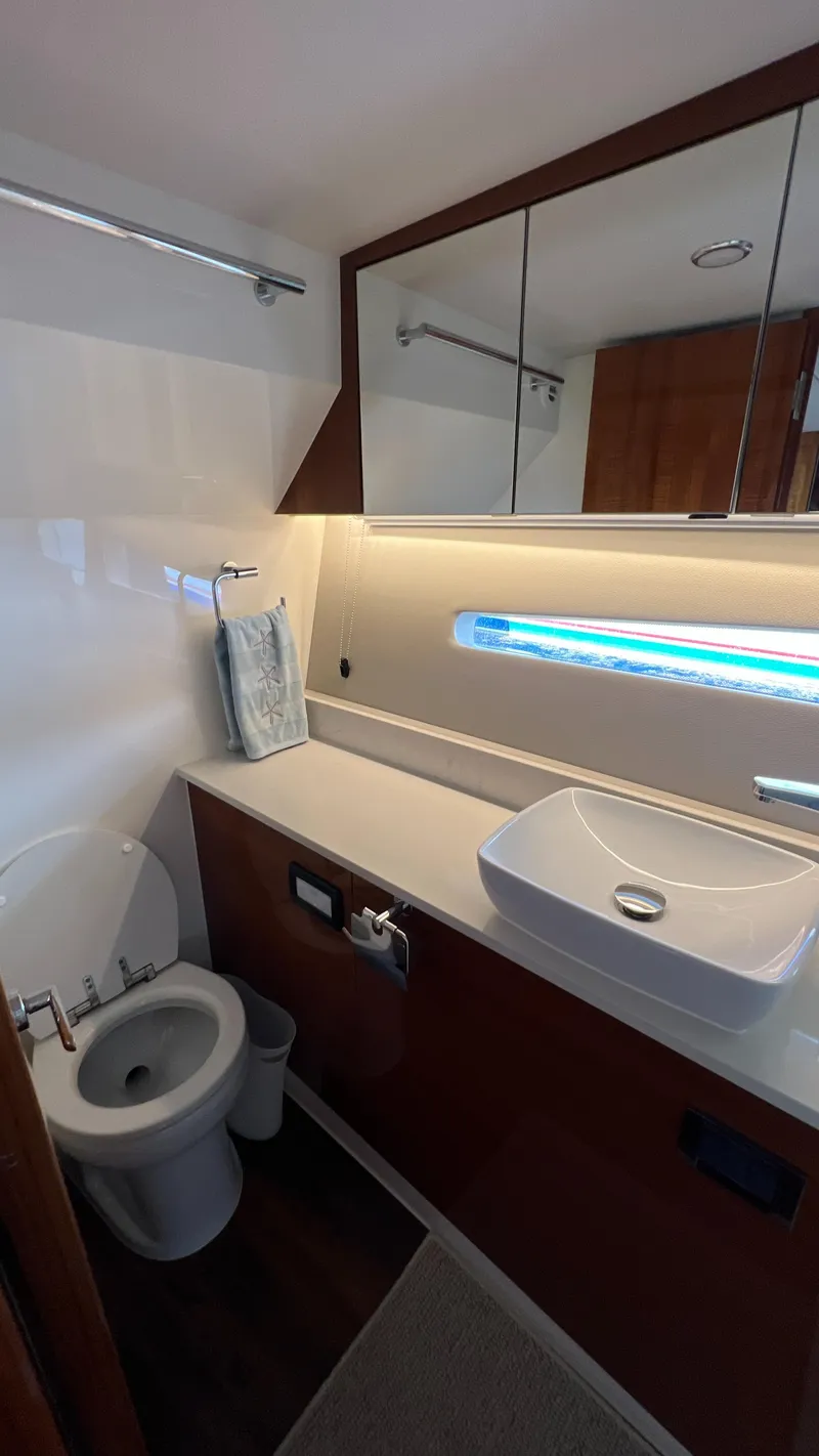Slide: The Image of 2021 Maritimo X60 yacht bathroom with modern sink, toilet, and mirrored cabinet. - 44