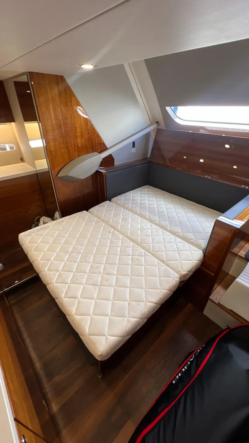 Slide: The Image of 2021 Maritimo X60 yacht interior with luxurious twin beds and wooden accents. - 46