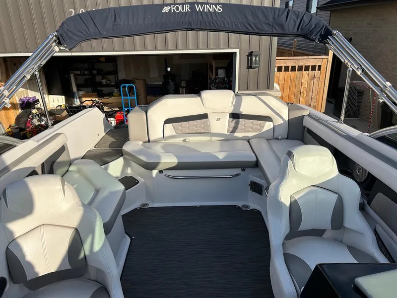 Slide: The Image of 2018 Four Winns HD220 boat interior with spacious seating and canopy. - 12