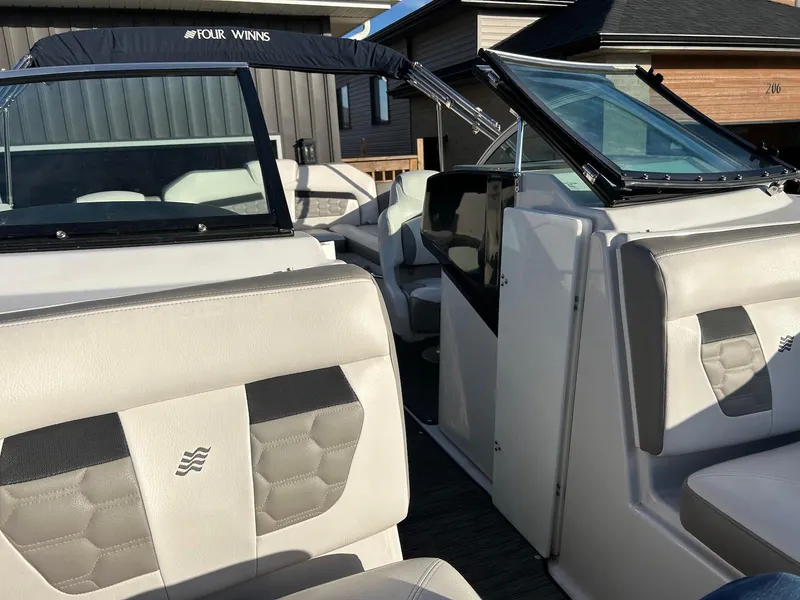 Slide: The Image of 2018 Four Winns HD220 boat interior with beige seating and open windshield. - 14