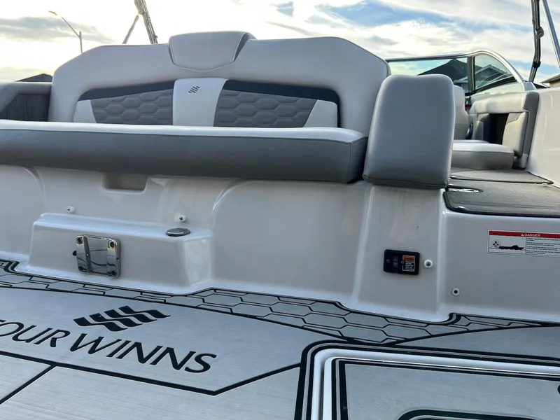 Slide: The Image of 2018 Four Winns HD220 boat interior with gray seating and branded flooring. - 18