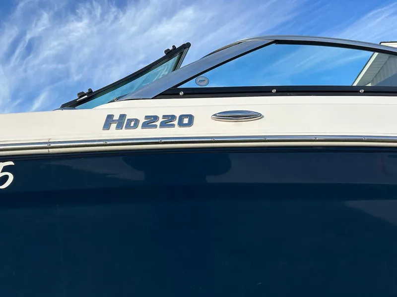 Slide: The Image of 2018 Four Winns HD220 boat with sleek design against a blue sky background. - 23