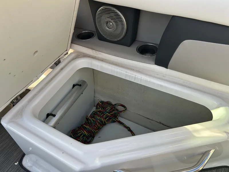 Slide: The Image of Open storage compartment in 2018 Four Winns HD220 boat with speaker and cup holders. - 27