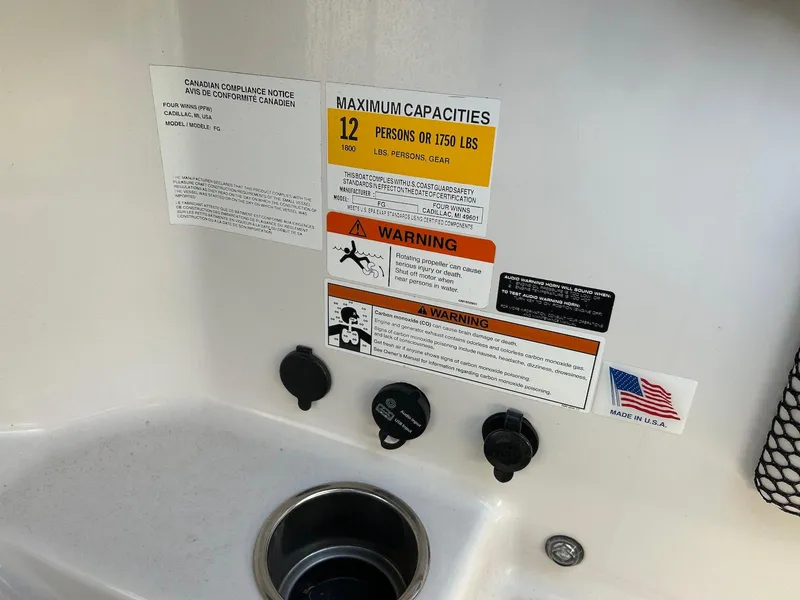 Slide: The Image of 2018 Four Winns HD220 boat capacity and warning labels near sink area. - 33