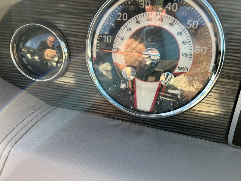 Slide: The Image of Dashboard of a 2018 Four Winns HD220 boat, featuring speedometer and gauges. - 35