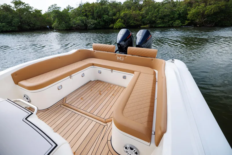 Slide: The Image of 2024 Nuova Jolly Prince 38 boat with tan seating and twin engines on a calm river. - 13