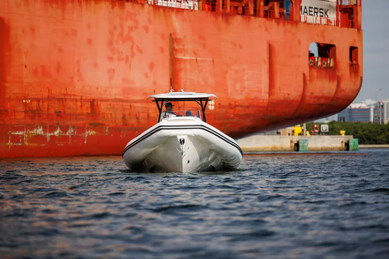 Slide: The Image of Nuova Jolly Prince 38 boat, 2024 model, cruising near a large cargo ship. - 20