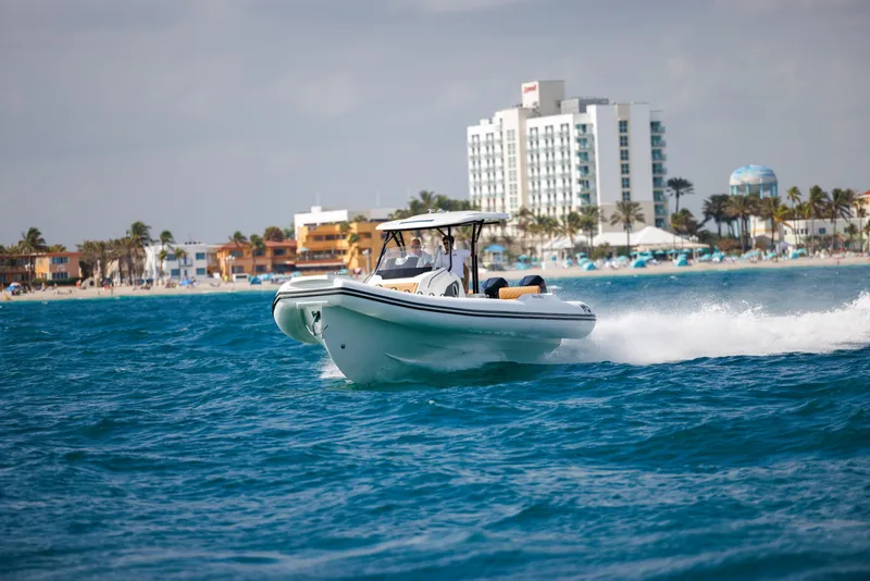 Slide: The Image of 2024 Nuova Jolly Prince 38 boat cruising near a coastal cityscape. - 23