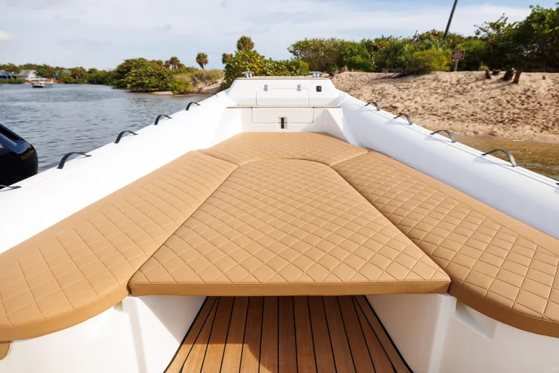 Slide: The Image of 2024 Nuova Jolly Prince 38 boat with tan cushioned deck, docked by sandy shore. - 30