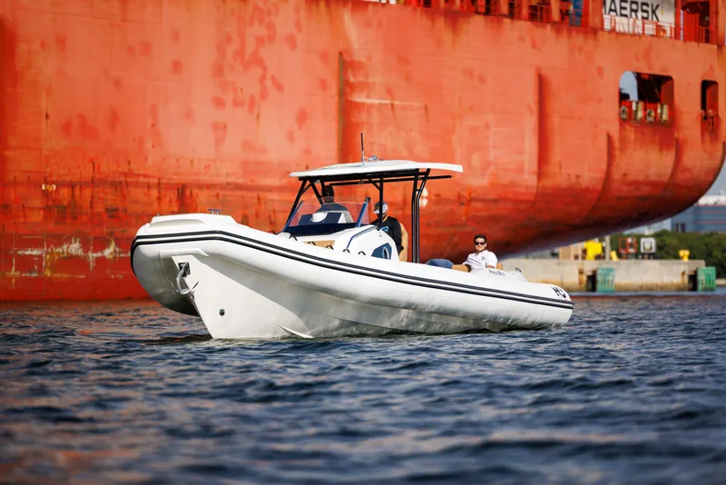 Slide: The Image of 2024 Nuova Jolly Prince 38 boat cruising near a large cargo ship. - 5