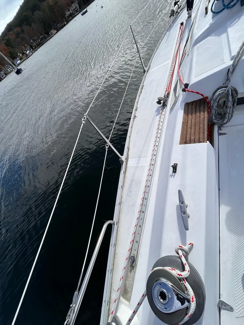 Slide: The Image of 1983 Hunter 34 sailboat deck with ropes and winch, moored on calm water. - 13