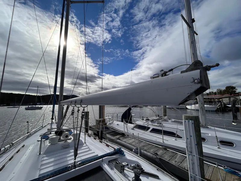 Slide: The Image of 1983 Hunter 34 sailboat docked under a partly cloudy sky. - 19