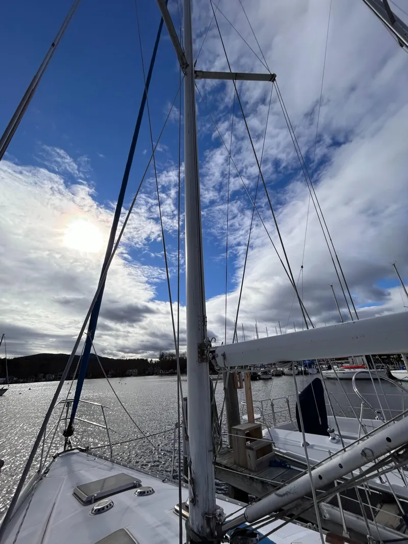 Slide: The Image of 1983 Hunter 34 sailboat mast against a cloudy sky in a marina. - 20