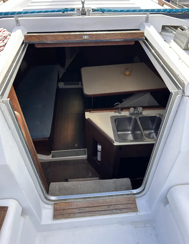 Slide: The Image of Interior view of 1983 Hunter 34 sailboat, featuring a compact kitchen and dining area. - 27