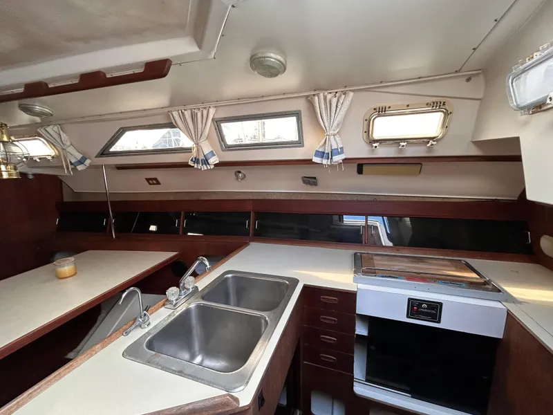 Slide: The Image of Interior of 1983 Hunter 34 sailboat kitchen with sink, stove, and windows. - 32