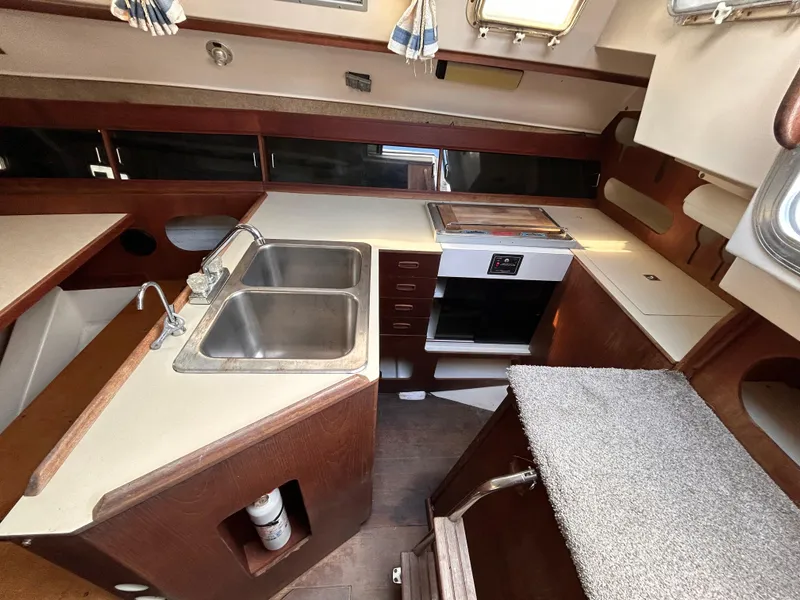 Slide: The Image of 1983 Hunter 34 sailboat kitchen with dual sinks and stove. - 33