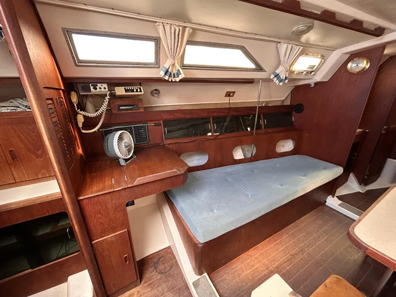 Slide: The Image of Interior of 1983 Hunter 34 sailboat with wooden furnishings and blue cushioned seating. - 36