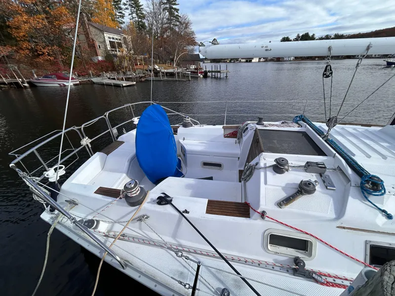 Slide: The Image of 1983 Hunter 34 sailboat docked on a calm lake with autumn foliage. - 4