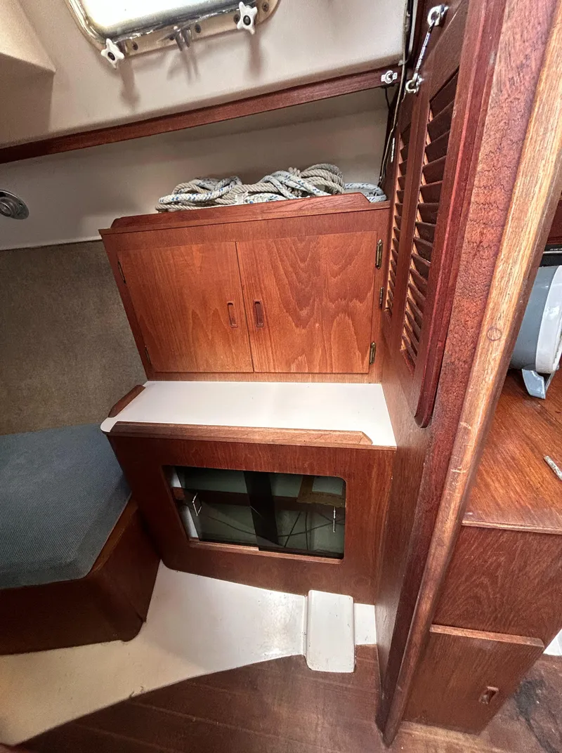 Slide: The Image of 1983 Hunter 34 sailboat interior with wooden cabinetry and storage space. - 44