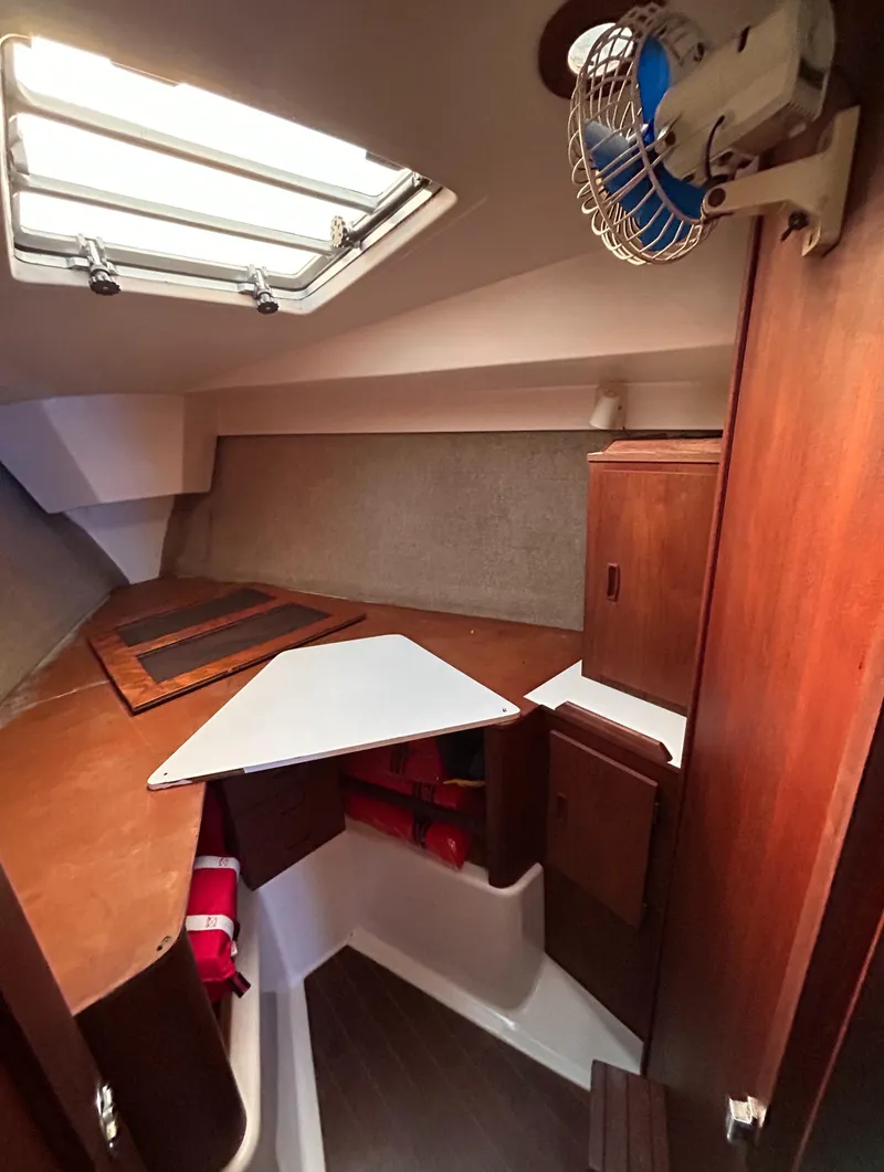 Slide: The Image of 1983 Hunter 34 sailboat interior with wood cabinetry and storage compartments. - 49