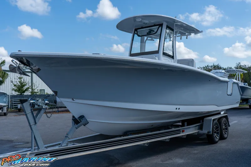 Slide: The Image of 2025 Sea Hunt Gamefish 27 boat on trailer, side view under blue sky. - 19