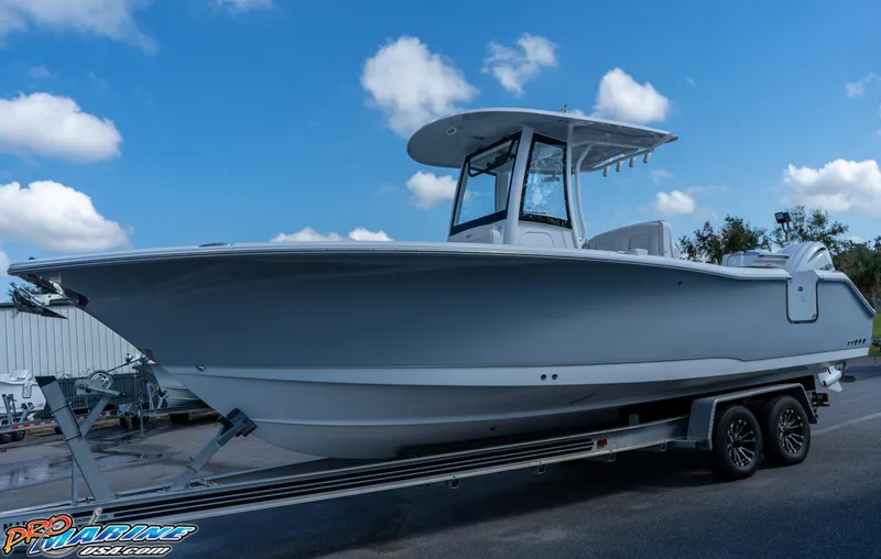 Slide: The Image of 2025 Sea Hunt Gamefish 27 boat on trailer under blue sky. - 20