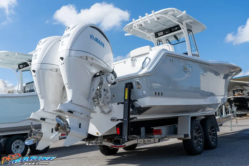 Slide: The Image of 2025 Sea Hunt Gamefish 27 with Coffin Box, dual Yamaha engines, on trailer, sunny day. - 26