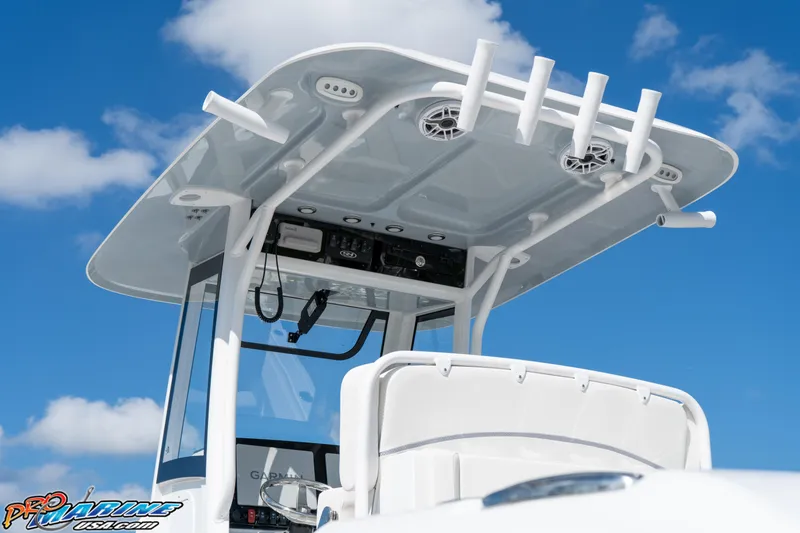 Slide: The Image of 2025 Sea Hunt Gamefish 27 boat with T-top and rod holders against blue sky. - 29