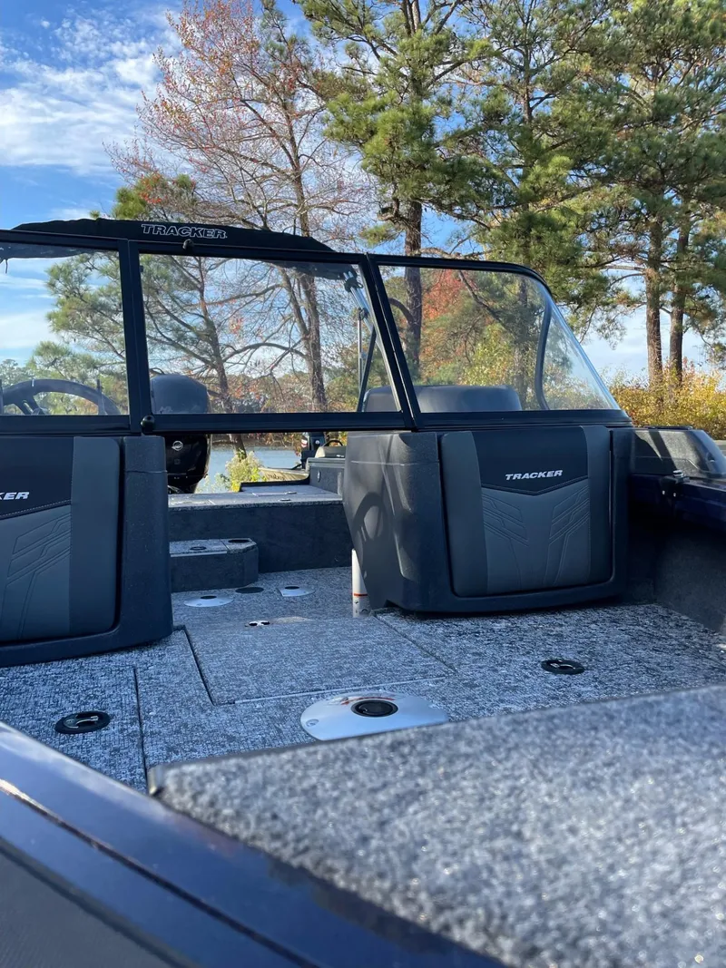 Slide: The Image of 2025 Tracker Targa V-18 WT boat interior with trees in the background. - 2