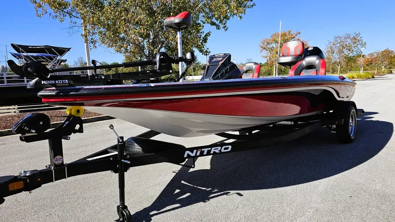Slide: The Image of 2025 Nitro Z19 boat on trailer, red and black design, parked outdoors. - 7