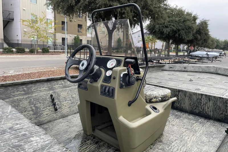 Slide: The Image of 2025 Tracker Grizzly 2072 CC boat interior with steering console and camouflage seating. - 6