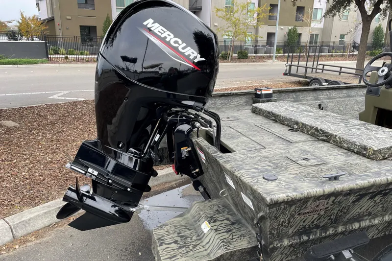 Slide: The Image of 2025 Tracker Grizzly 2072 CC boat with Mercury outboard motor, parked on street. - 8