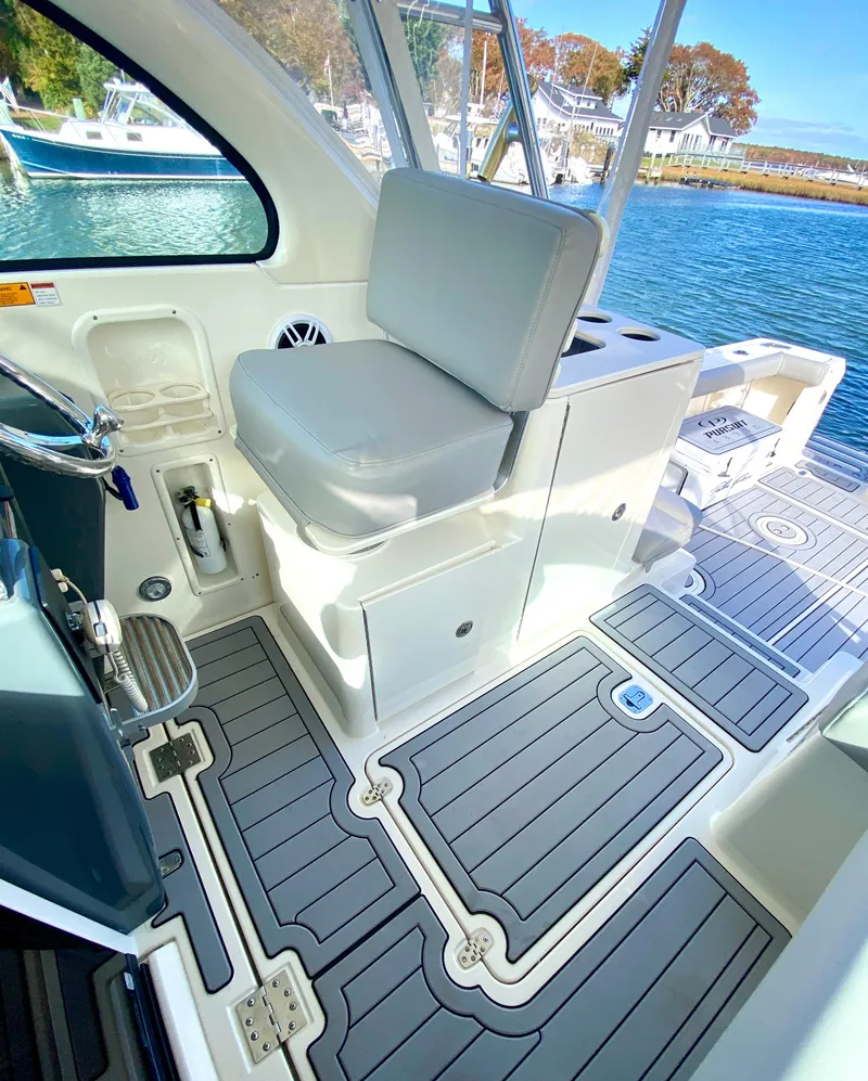 Slide: The Image of 2004 Pursuit 3100 Offshore boat interior with cushioned seating and sleek flooring. - 13