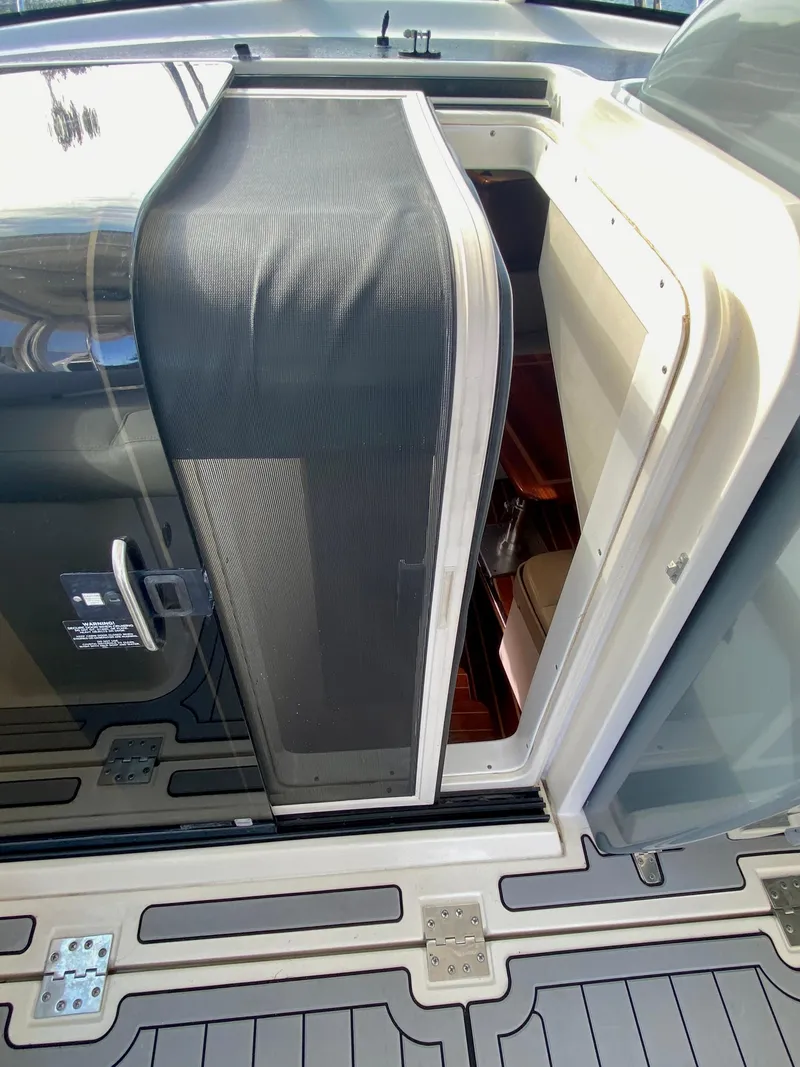 Slide: The Image of 2004 Pursuit 3100 Offshore cabin entrance with open door and screen. - 16