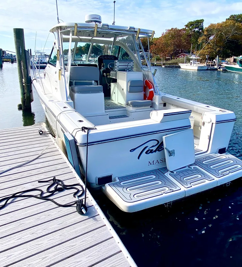 Slide: The Image of 2004 Pursuit 3100 Offshore boat docked at marina, rear view. - 3