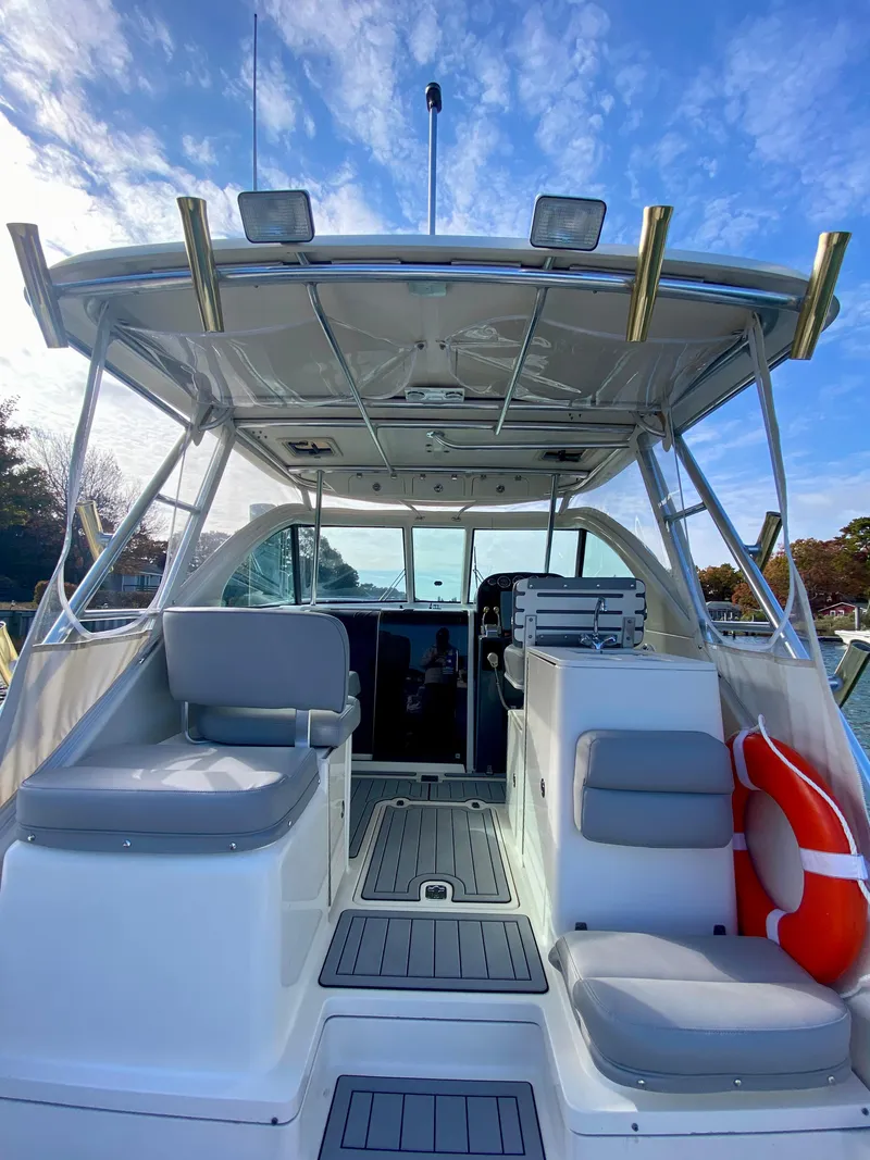 Slide: The Image of 2004 Pursuit 3100 Offshore boat interior with seating and life preserver under a blue sky. - 5