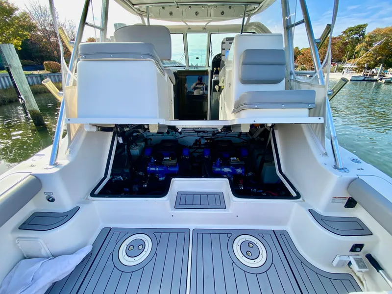Slide: The Image of 2004 Pursuit 3100 Offshore boat with open engine compartment, docked by the water. - 6