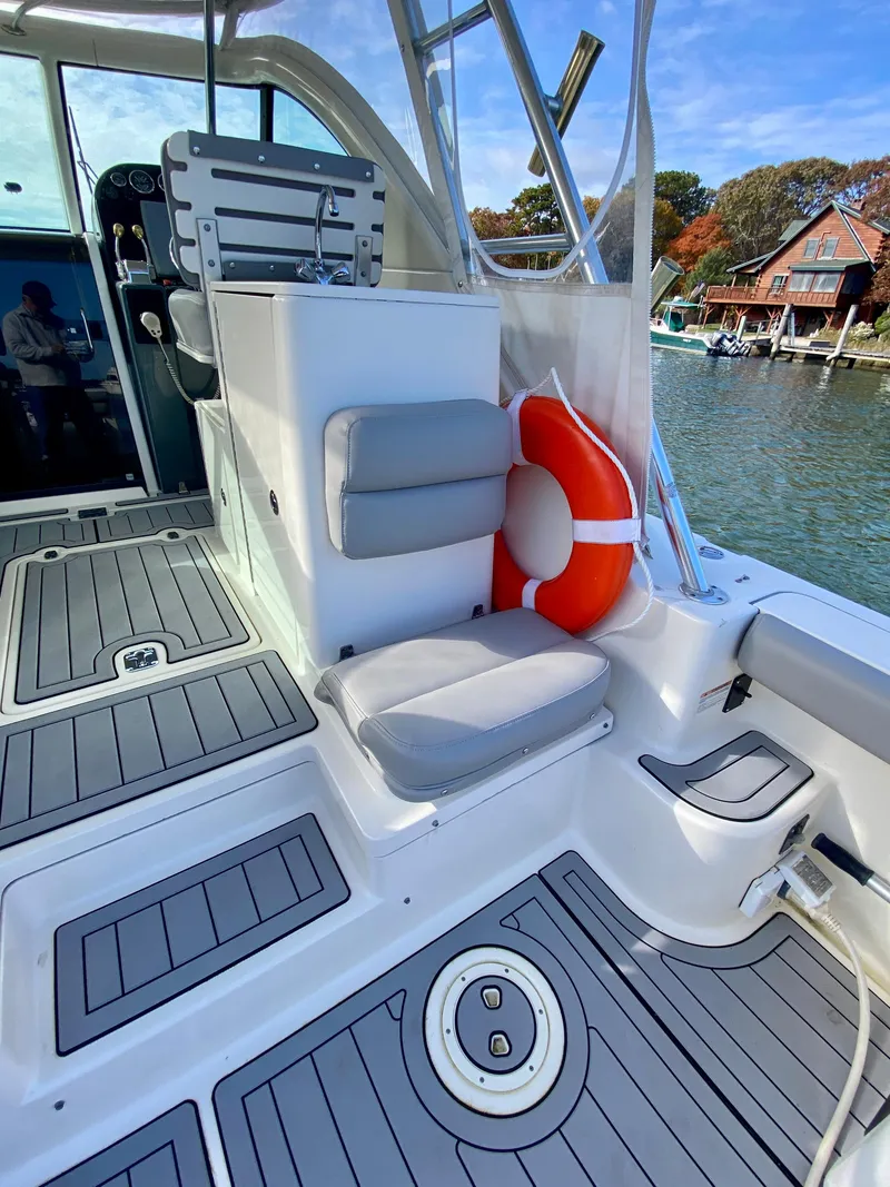 Slide: The Image of 2004 Pursuit 3100 Offshore boat interior with seating and life preserver, dockside view. - 7