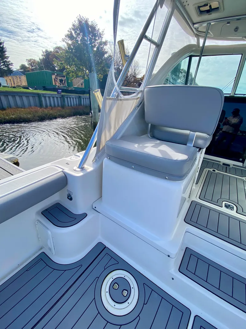 Slide: The Image of 2004 Pursuit 3100 Offshore boat interior with seating and deck view. - 9