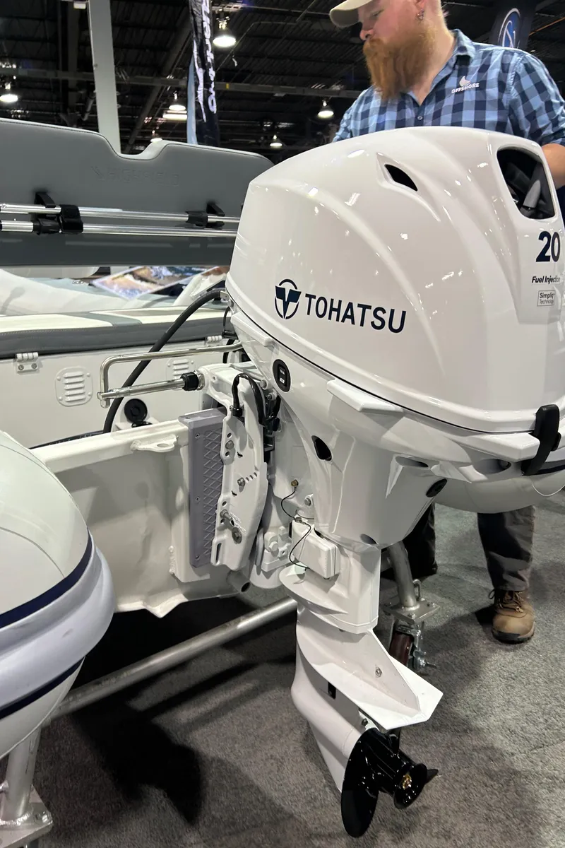 Slide: The Image of 2025 Highfield Classic 310 FCT with Tohatsu outboard motor at a boat show. - 10