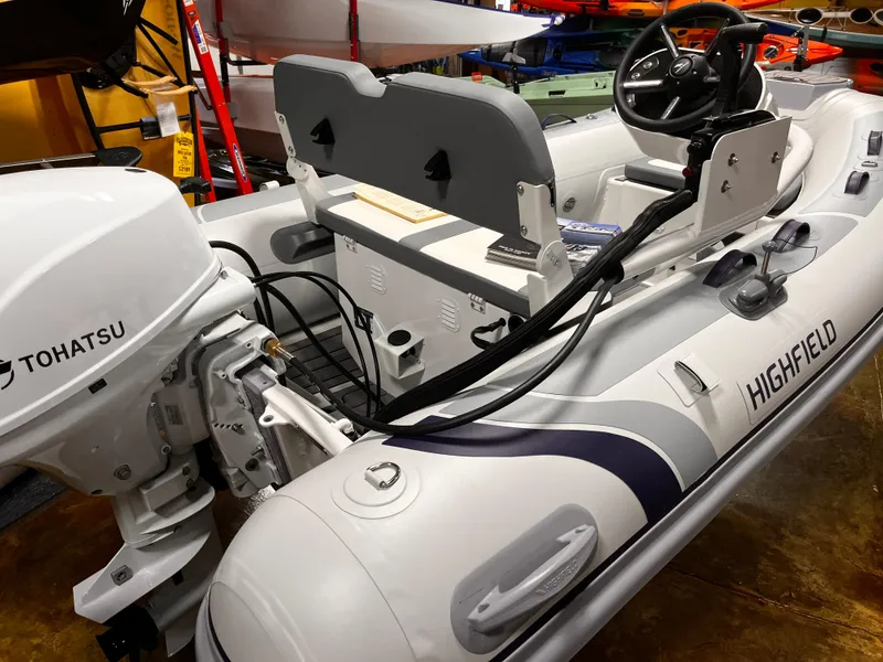 Slide: The Image of 2025 Highfield Classic 310 FCT inflatable boat with Tohatsu outboard motor in showroom. - 15
