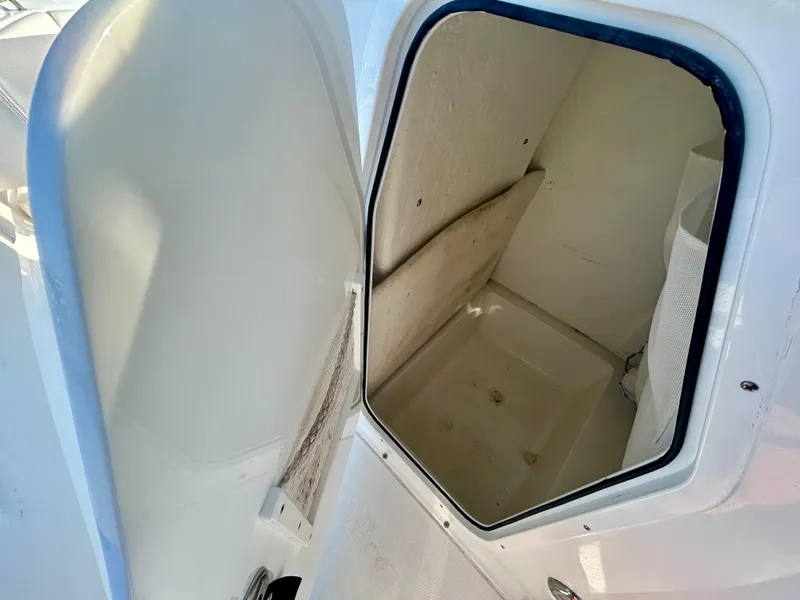 Slide: The Image of 2023 Sea Hunt Ultra 219 boat storage compartment, open door view. - 10