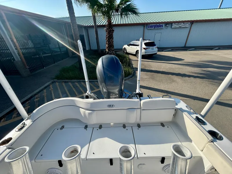 Slide: The Image of 2023 Sea Hunt Ultra 219 boat with motor in a sunny parking lot. - 14